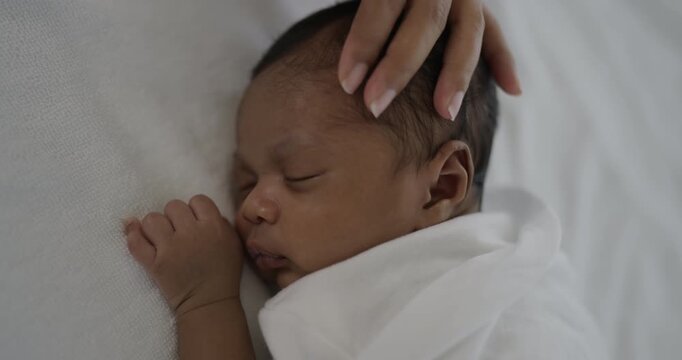 African black parent hands pad on newborn baby head, Closeup mother&rsquo;s hand holding their new born baby. Together love harmony family nursery healthcare and medical father&rsquo;s day 