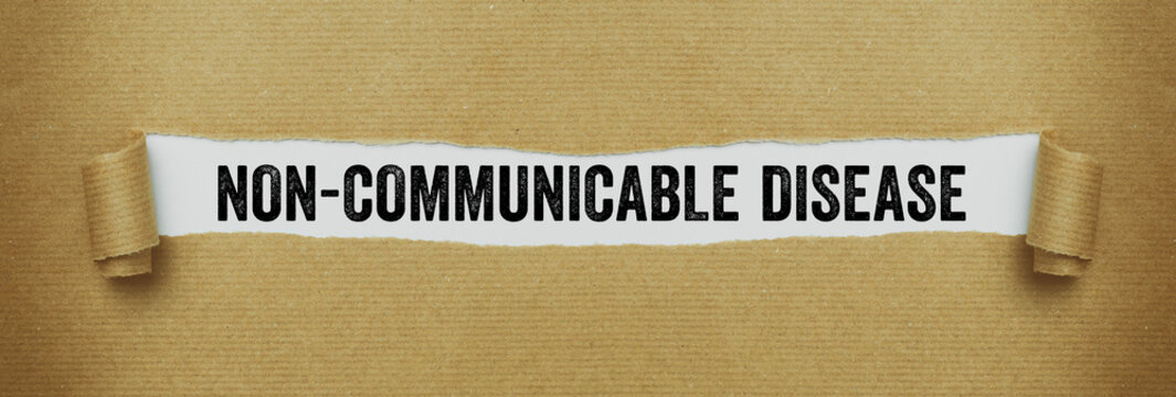 Torn paper revealing the word Non-communicable disease