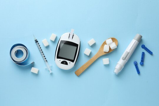 Diabetes. Flat lay composition with digital glucometer, pen and lancets on light blue background
