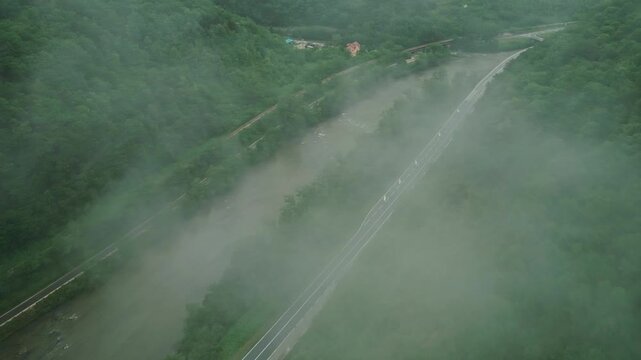 Aerial view of river canyon with road and low clouds