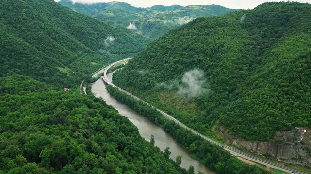 Aerial view of river canyon with road and low clouds