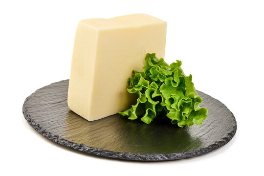 Block of cheese with fresh lettuce on a slate board