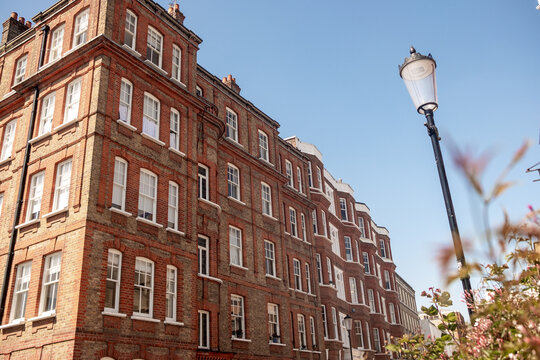 KENSINGTON W8 &ndash; upmarket red brick Victorian residential property exterior under clear blue skies in prime London area