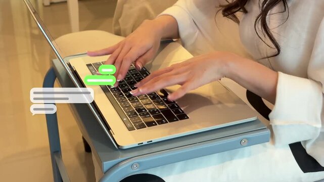 Wide 4K shot of an East Asian woman fast typing on a laptop keypad inside a room as text graphic bubbles pop up rapidly.