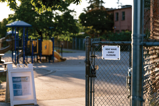 A heat wave early closure notice attached to a gate, emphasizing the importance of safety measures during extreme weather conditions in playgrounds and other educational settings.