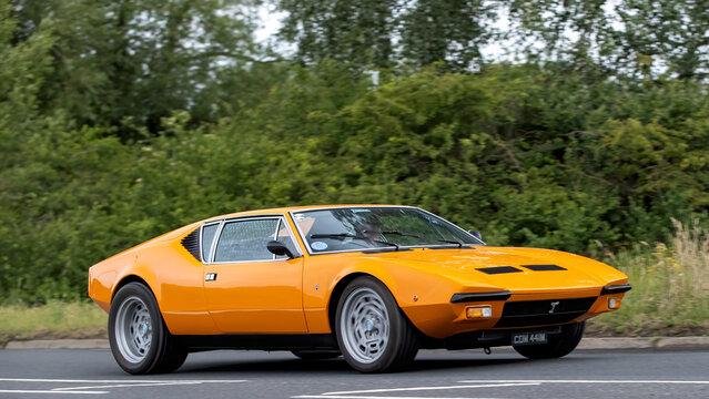 Stony Stratford,Bucks,UK - June 7th 2026:  1974 orange De Tomaso Pantera classic car driving on a British road