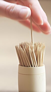 Picking sharp toothpick from retro style case close up