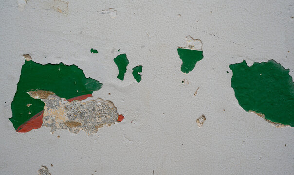 Textura de pared antigua con pintura verde descascarada y superficie de concreto deteriorada