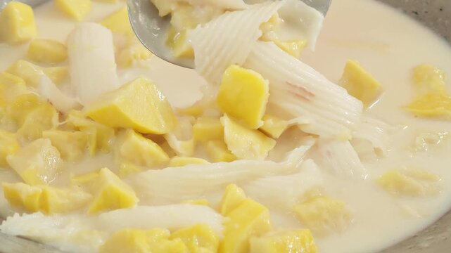 Colorful Bua Loy Thai dessert rice balls in coconut milk with poached egg