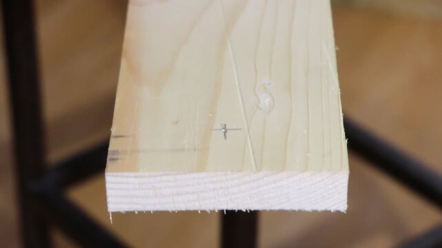 Measuring and Drilling a Large Hole in a Wooden Plank Using a Flat Spade Bit