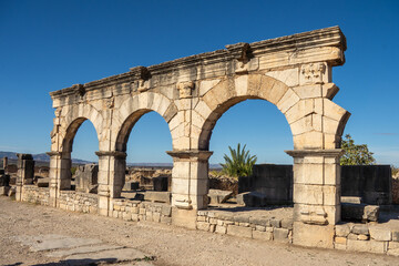 Obraz premium Arched openings in the ruins of a stone wall of Volubilis, outside of Meknes, Morocco