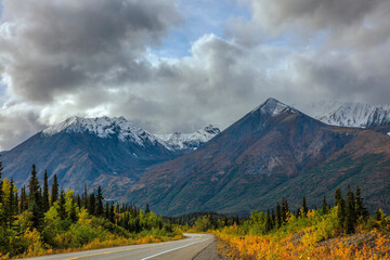 Mountain road winding through wilderness toward distant peaks © jia
