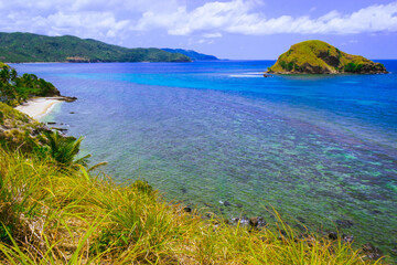 Fototapeta premium View of the sea from the grassy mountain. Calabogo Lighthouse, Romblon Island, Philippines