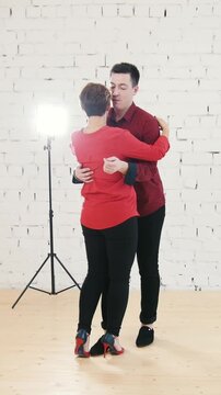 Family couple - male and female is dancing kizomba in white studio near window