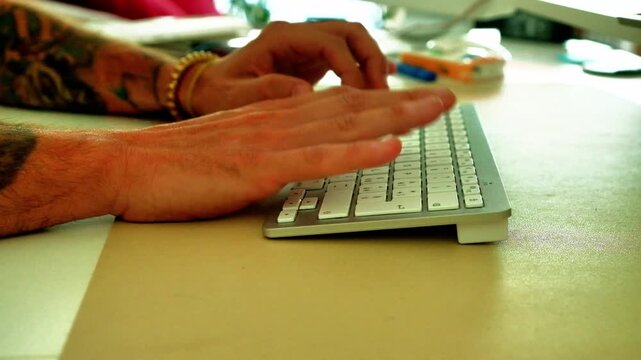 A man's hand types on a laptop keyboard. The video recalls several concepts such as remote working, connectivity and technology