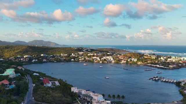 Aerial view of Oyster Pond on Saint Martin island in the Caribbean Sea. Coastal town with residential buildings and resort hotels is located on the border of French and Dutch sides. 