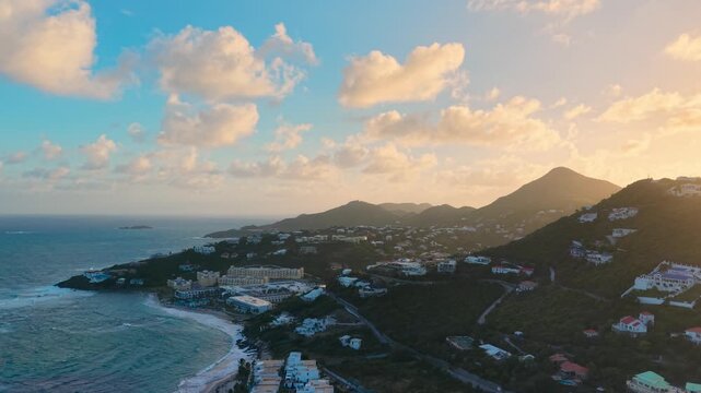 Aerial view of the resort coastline and lush green hills on the island of Saint Martin in the Caribbean Sea. This footage showcases luxury villas and hotels nestled along the shores of Oyster Pond. 