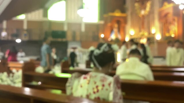 Wedding photoshoot at the altar of a chapel featuring the newlywed couple along with their entourage. Blurs