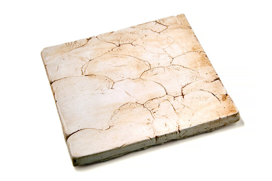 Ceramic tile with cracks and chips isolated on white background.