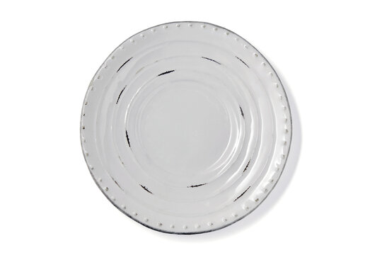 White ceramic plate in rustic style isolated on white background top view.