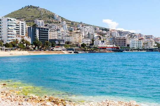 Beautiful beach with white pebbles and blue waters in european city.