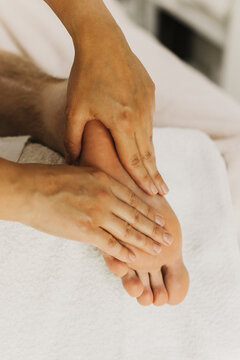 Close up of foot massage therapy session. Female massage therapist's hands.