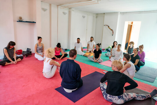 Group Yoga Class Meditation And Mindfulness Session In Studio With Diverse Adults Sitting In Circle
