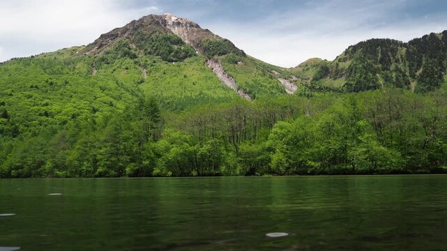 初夏の観光名所上高地の大正池と新緑の森と穂高連峰の風景