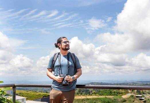 Male traveler with camera looking away at viewpoint in Colombia