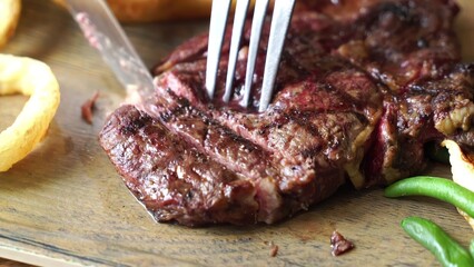 Juicy grilled steak on wooden cutting board with lemon and herbs © Gutium