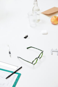 Green designer glasses on a creative workspace with technical tools