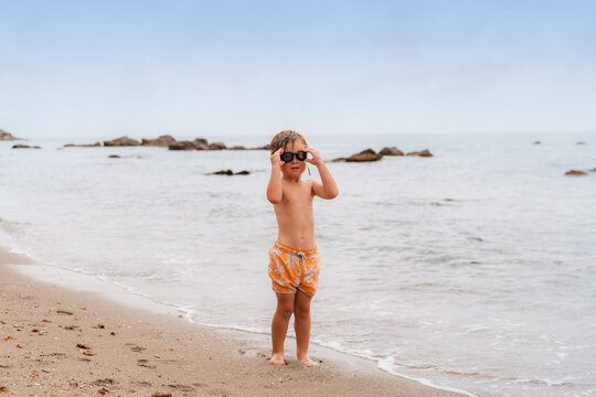 Boy in goggles standing at beach 