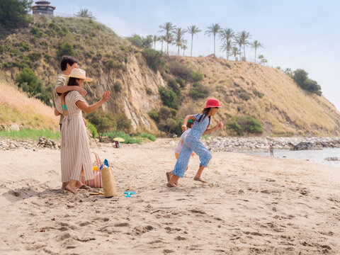 Family Enjoys Fun Day at the Beach With Children 