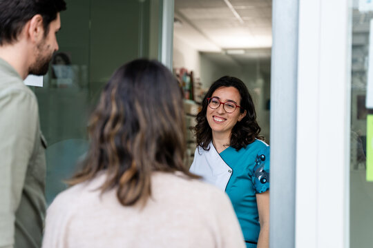 Optometrist Assisting Couple At Counter