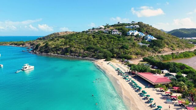 Aerial view of Friar's Bay Beach located on the French side of Saint Martin island in the Caribbean Sea. A scenic salt pond named Etang Guichard is visible on the right side next to the shoreline.