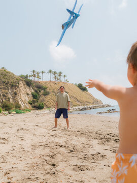 Boy throwing toy plane to his father 