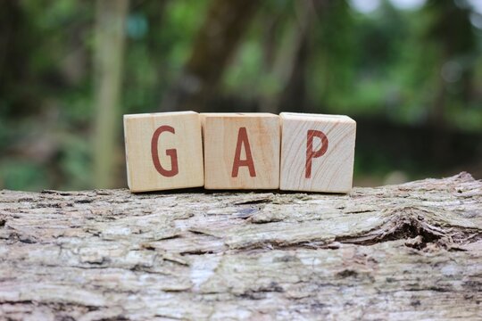 Wooden letter blocks spelling out GAP with a blurred background. Can be used for business, marketing, and financial concepts. Selective focus.