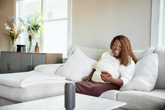 Woman Sits on Couch With Phone in Living Room