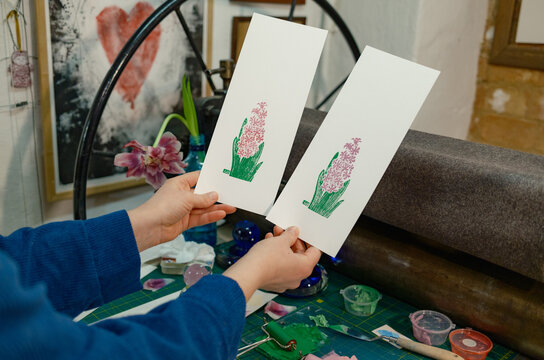 the hands of a female artist working in her studio and creating engrav