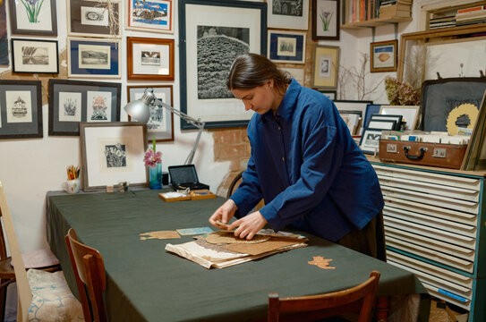 a female artist lays out her works on a table