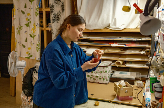 A female artist selects paints at a stand to create prints
