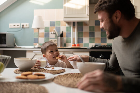 Little boy having breakfast with father