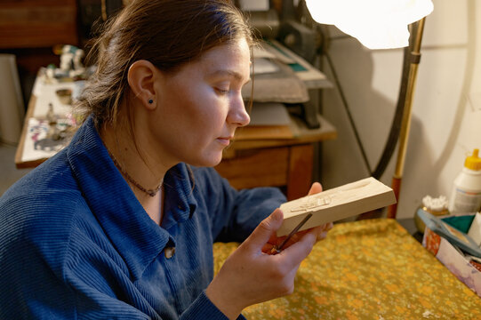 Female artist in her studio creating woodcut print