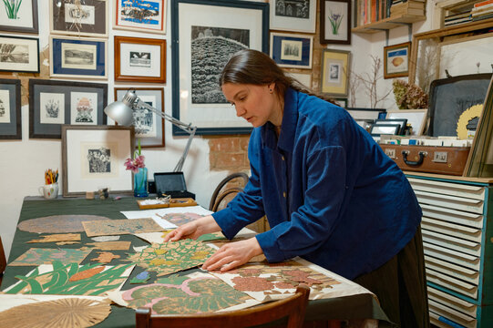 a female artist lays out her works on a table