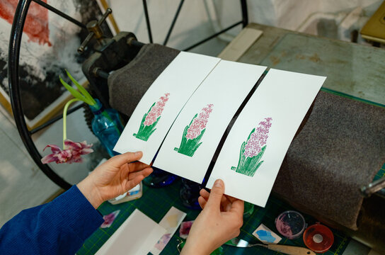 the hands of a female artist working in her studio and creating engrav