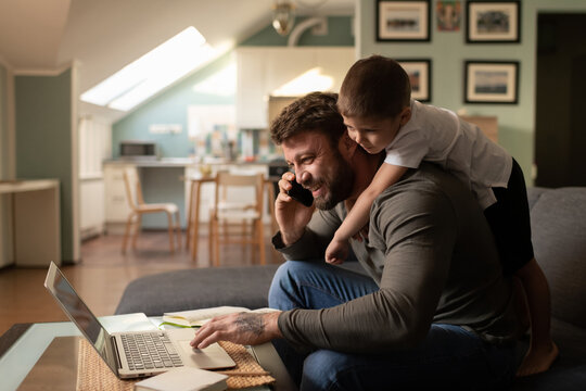 Cheerful father with son working from home