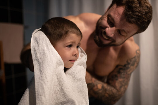 Father wiping face of son after shaving