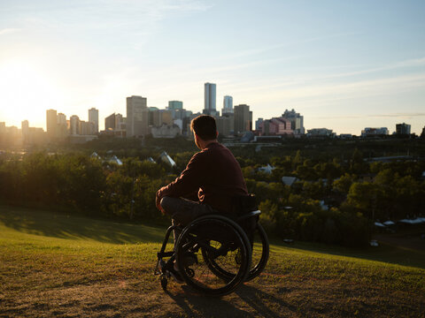 City skyline view from a hillside with a man in a wheelchair