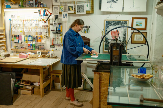 A female artist works at an engraving machine