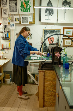 A female artist works at an engraving machine